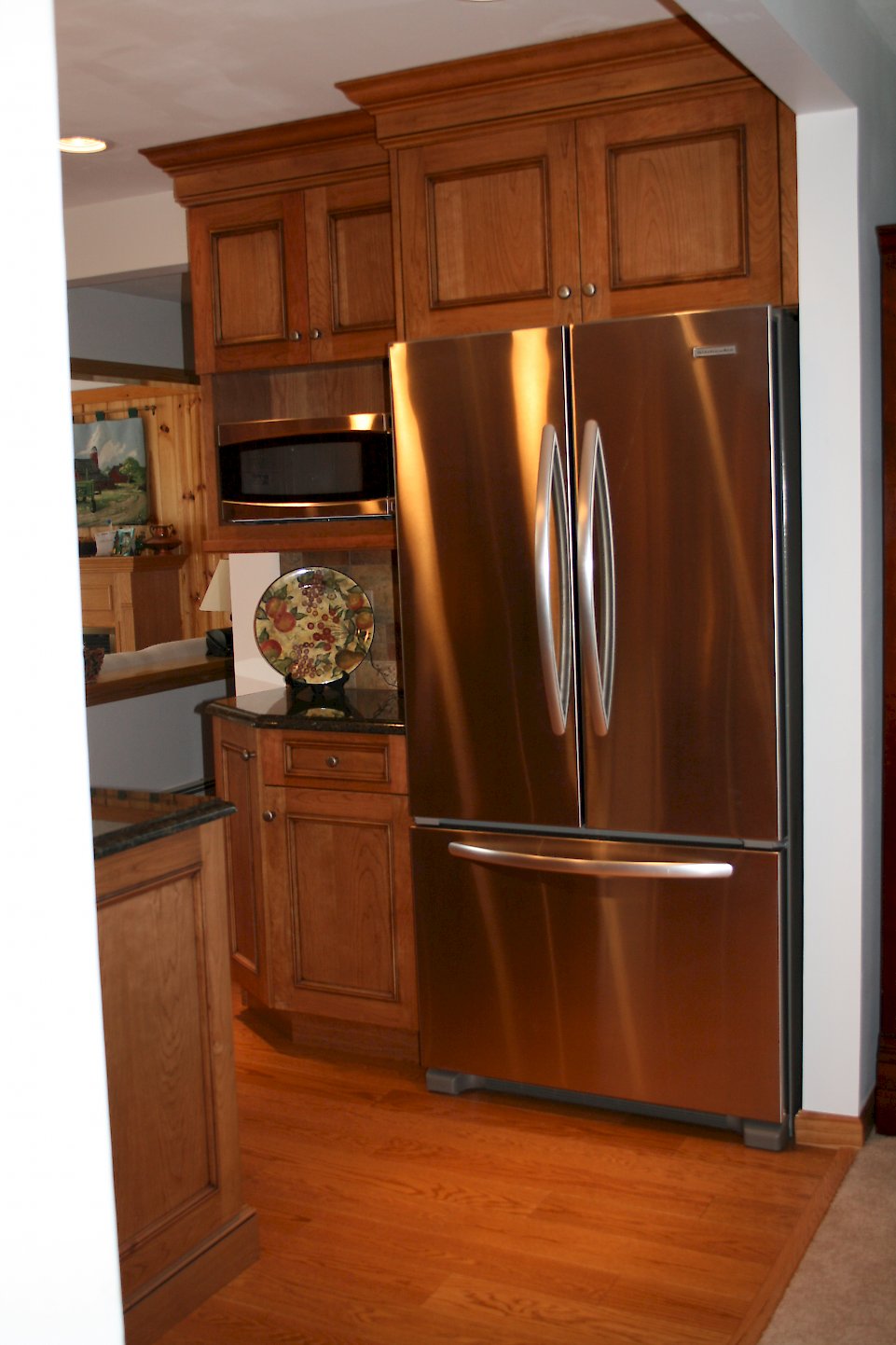 Closer view of the Refrigerator and GE microwave.