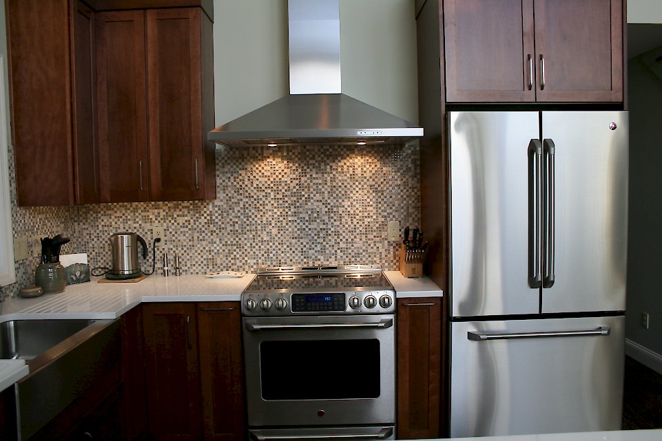 An XO brand chimney hood and GE Electric range.