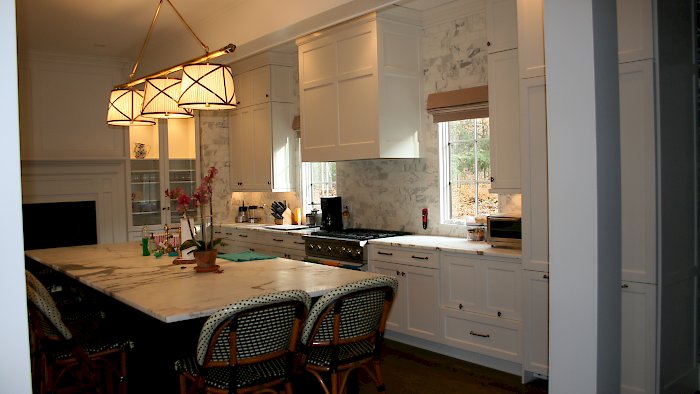 Alpine white maple Kitchen with a large black island.