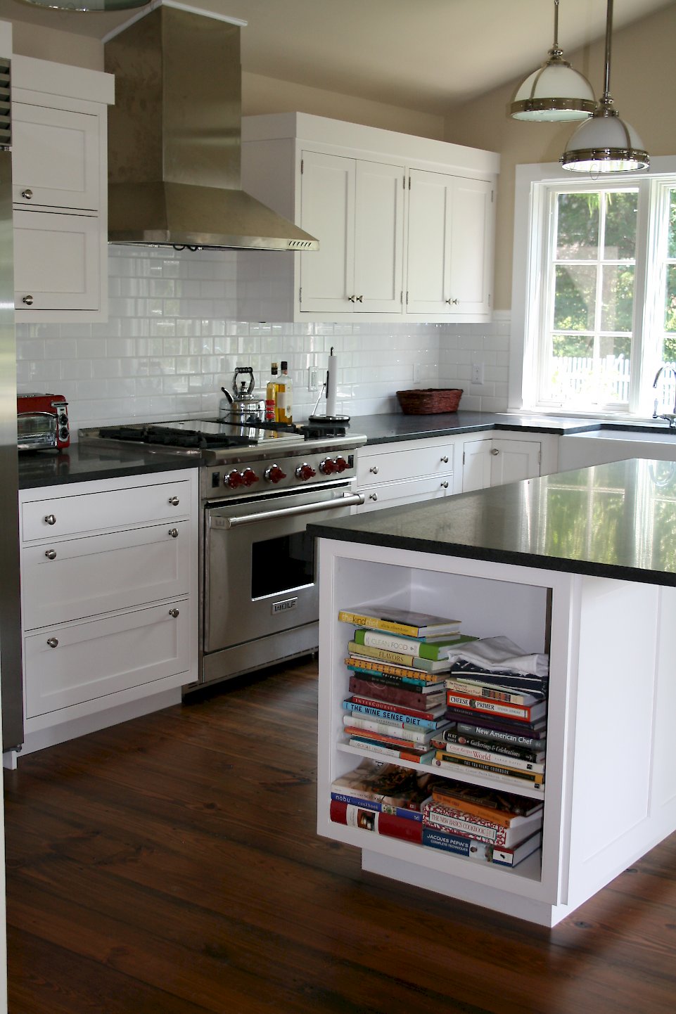 A stainless Wolf 36 inch range with red knobs.